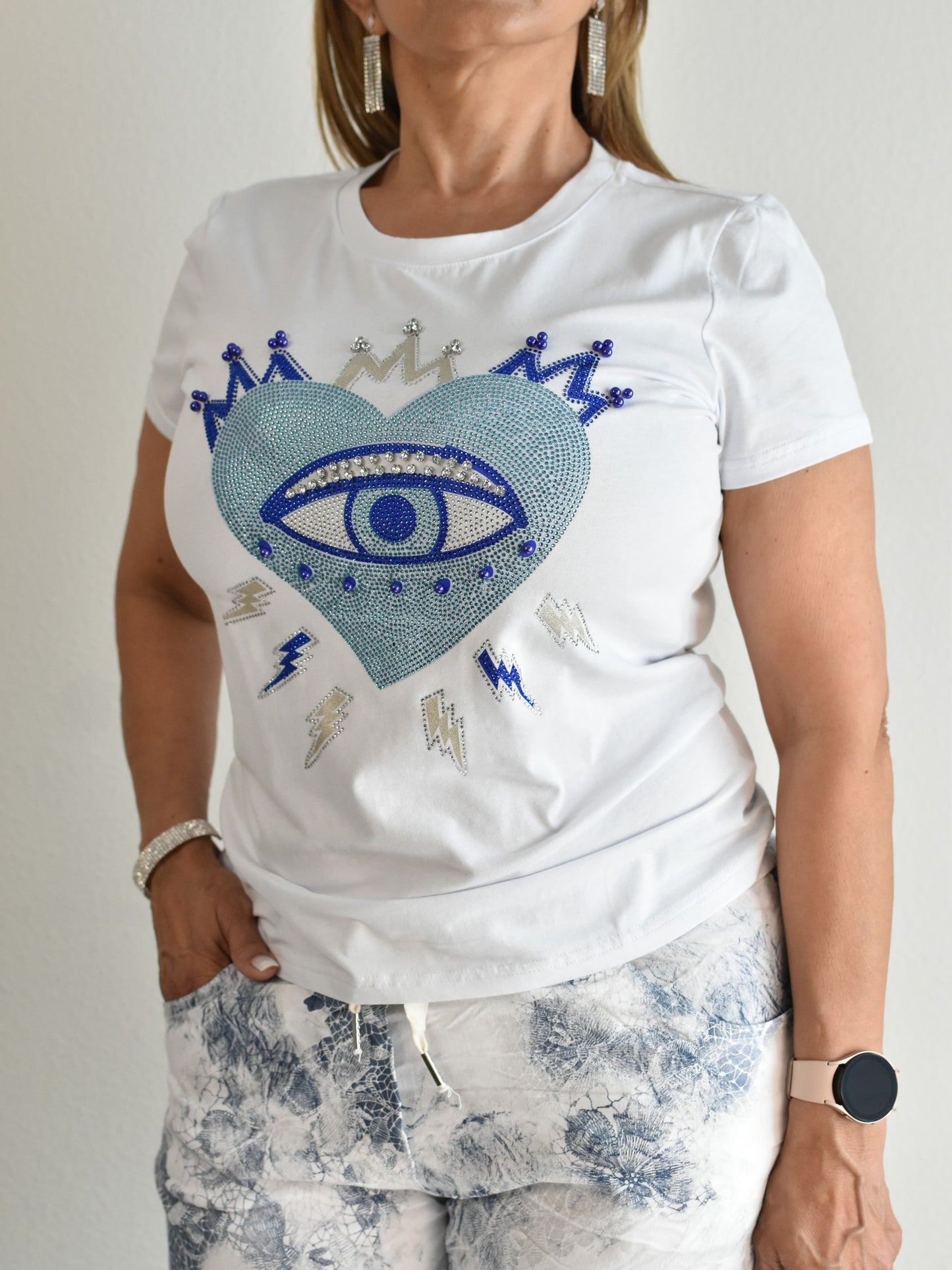 Camiseta blanca con diamantes de imitación en forma de ojo malvado